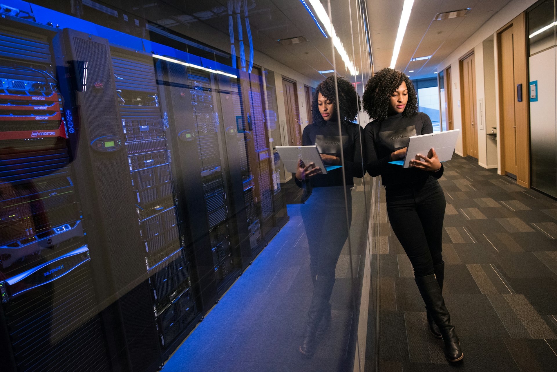 Engineer reviewing infrastructure on a laptop beside server racks